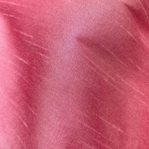 "Close-up of a pink faux silk fabric with a smooth and shiny texture. Faux silk is a synthetic alternative to real silk, offering a similar luxurious look and feel, perfect for various fashion and home decor applications."