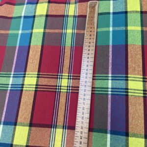 Colorful Cotton Madras checkered fabric draped elegantly, showcasing its vibrant hues and lightweight texture.