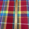 Colorful Cotton Madras checkered fabric draped elegantly, showcasing its vibrant hues and lightweight texture.